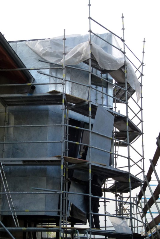 Die Dämmung ist eingeblasen. Das verzinkte Blech wird montiert. In mühevoller Handarbeit wird daraufhin geschwärzt.